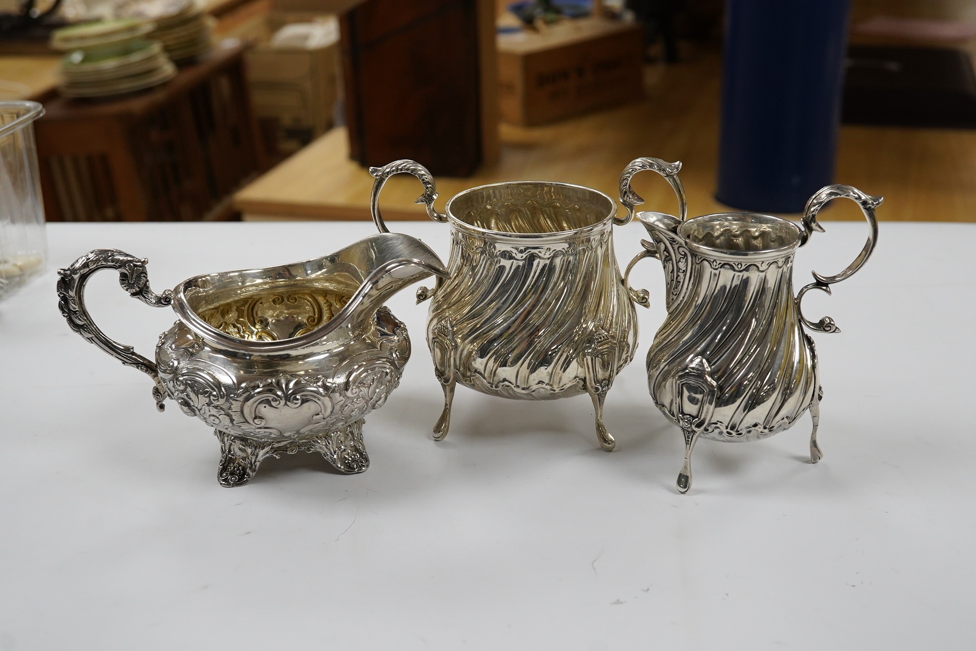 A late Victorian silver cream jug and sugar bowl, by Mappin & Webb, London, 1900 and an earlier William IV silver cream jug, London, 1835, 16.1oz. Condition - fair to good